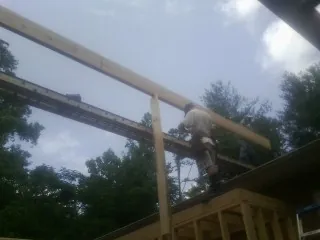 Carpenter setting a ridge beam over a new addition frame — Ice Dam Removal by Roofing Brothers in Bonner Springs