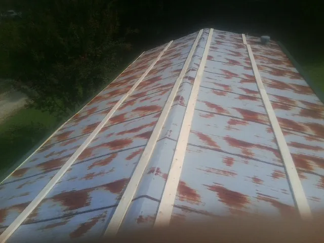 Rusted metal roof panels with new wood purlins before replacement — Storm Damage Roof Repair in Bonner Springs by Roofing Brothers