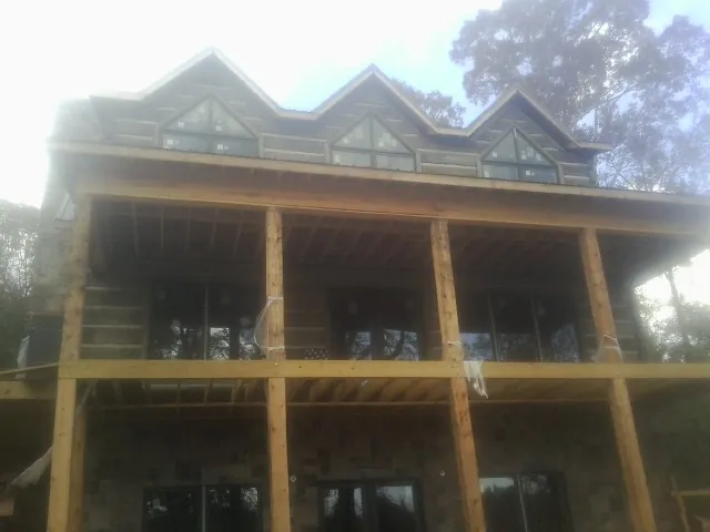 Dormers and porch framing on a large log home under construction — Roof Coating work by our crew in Bonner Springs