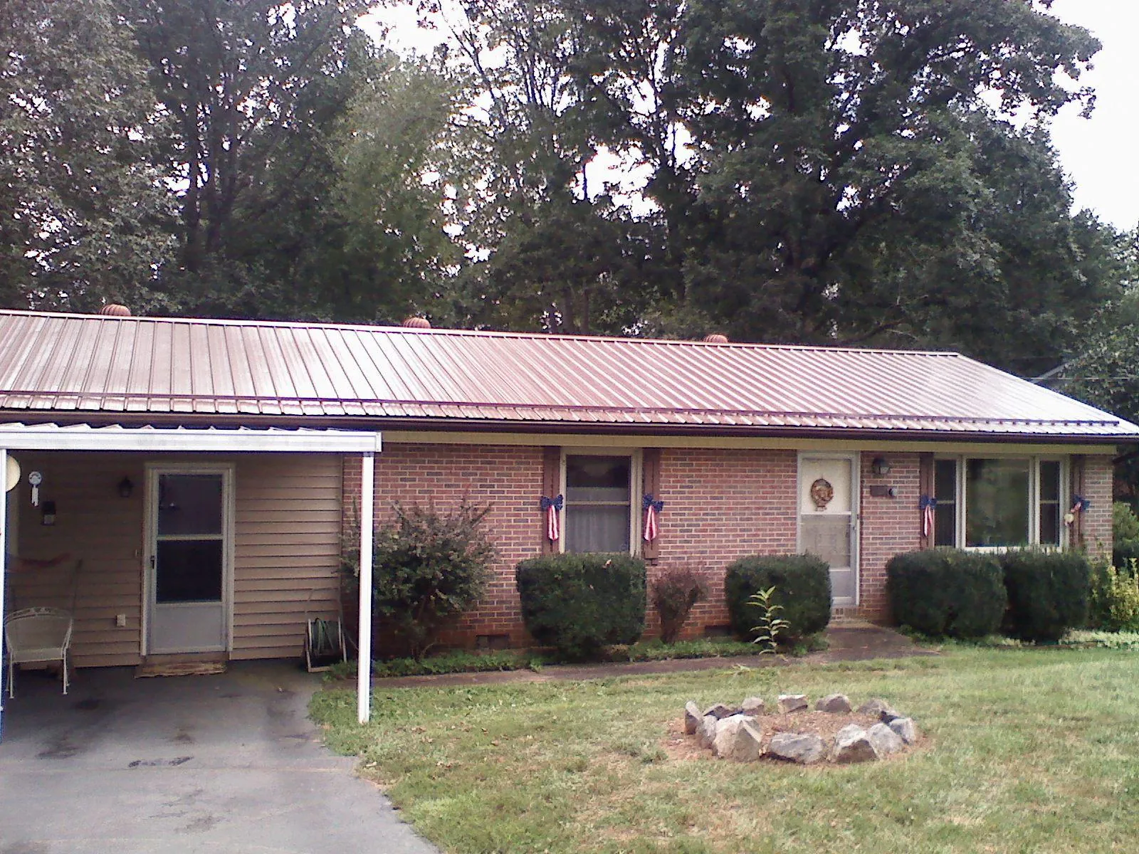 Bronze metal roof and carport on a brick ranch home — Roof Repair work by our crew in Bonner Springs